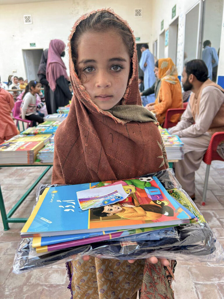 Grammar School Foundation students receiving free uniforms and books in rural Pakistan